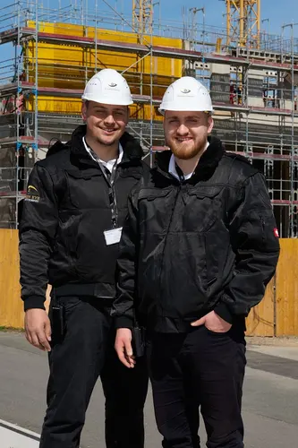 Zwei Sicherheitsdienst-Mitarbeiter mit Helm auf einer Baustelle in Ehingen - professionelle Baustellenbewachung und Schutz vor Diebstahl